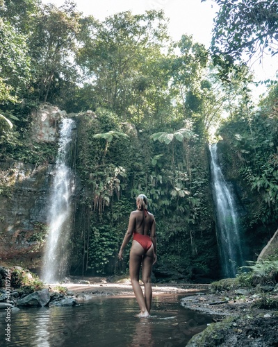 Fototapeta Naklejka Na Ścianę i Meble -  Woman in bikini at tropical waterfall in Lombok Indonesia