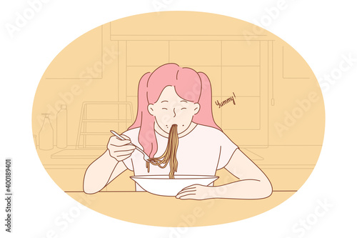 Eating yummy homemade food. Positive hungry girl sitting eating spaghetti pasta noodles with sauce for dinner at home. Healthy lunch meal supper meal cooked and served in plate 