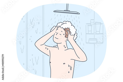 Taking shower and personal hygiene concept. Young smiling boy enjoying shampoo and hot water during taking shower in bathroom. Routine casual things for individual bodycare 