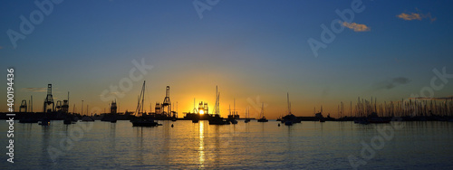 Sporting and commercial ports at sunrise with many sailboats, cranes and blue sky, Las Palmas of Gran Canaria