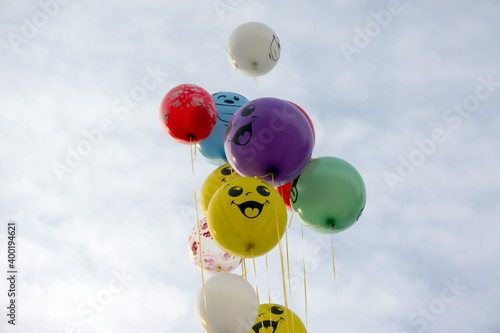 Fotografía A bunch of multi-colored balloons soar up to the cloudy sky.