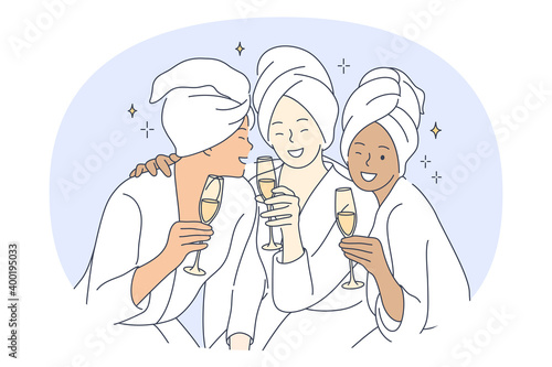 Bride and friends party, pajama party with friends concept. Young smiling multiethnic girls with glasses of champagne in towels and home clothing having fun and celebrating holiday together 