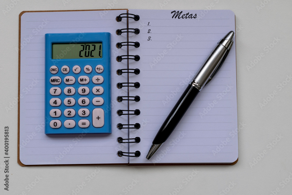goals for 2021, calculator, pen and notepad. Translation: goals, in Portuguese. goals for 2021, calculator, pen and notepad. Translation: goals, in Portuguese.