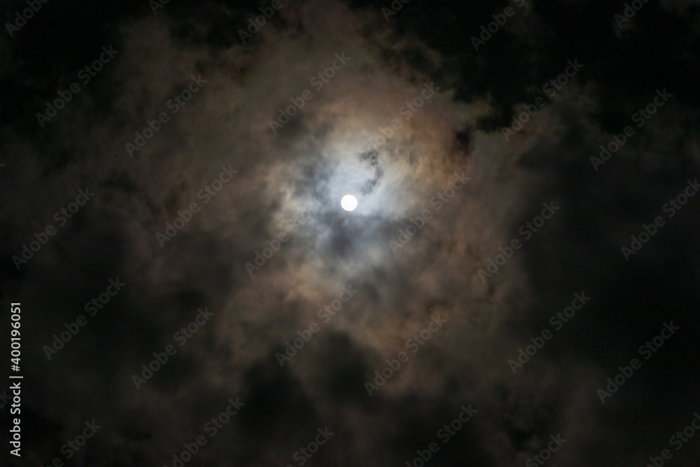 Full moon hidden in thin clouds