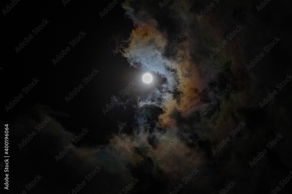 Full moon hidden in thin clouds