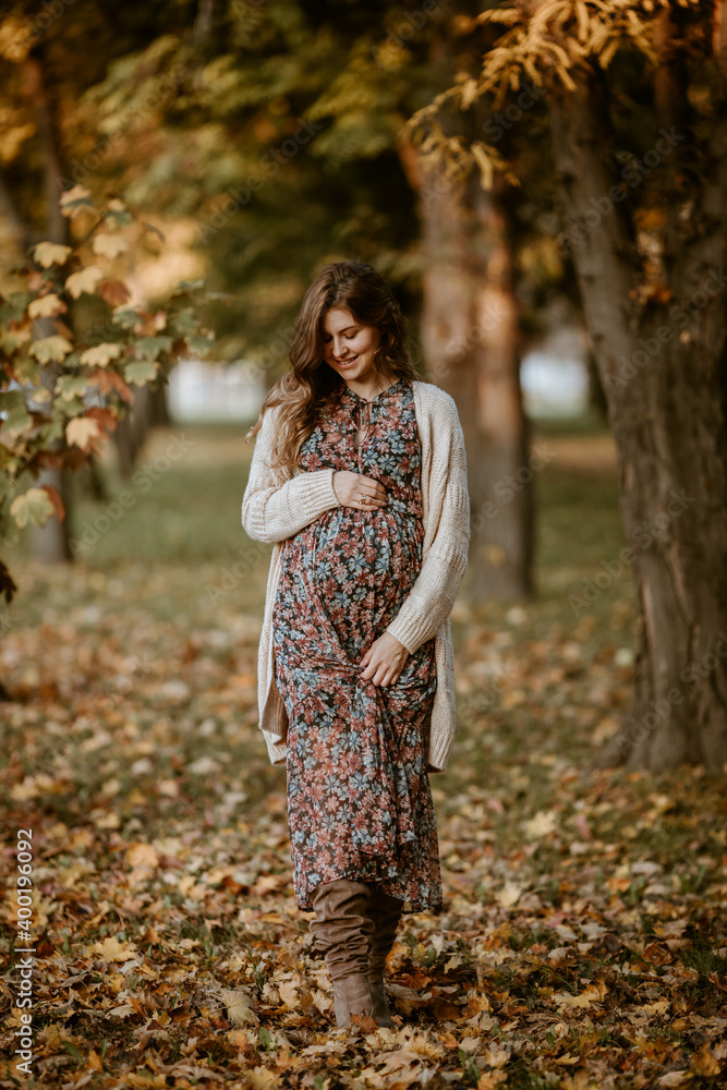 Lovely pregnant woman enjoying autumn in the park Lovely pregnant woman enjoying autumn in the park