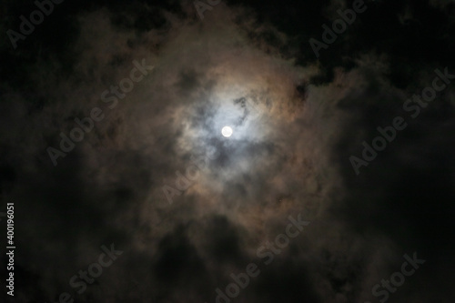 Full moon hidden in thin clouds