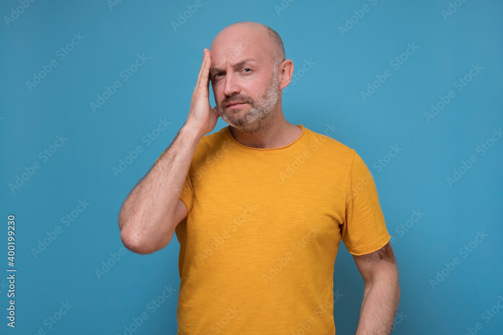 Mature man has to do hard decision try to solve his problem. Studio shoot on blue wall. Mature man has to do hard decision try to solve his problem. Studio shoot on blue wall.