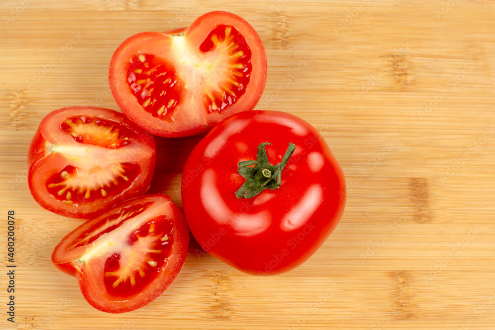 red tomatoes and tomato slices on a wooden board red tomatoes and tomato slices on a wooden board