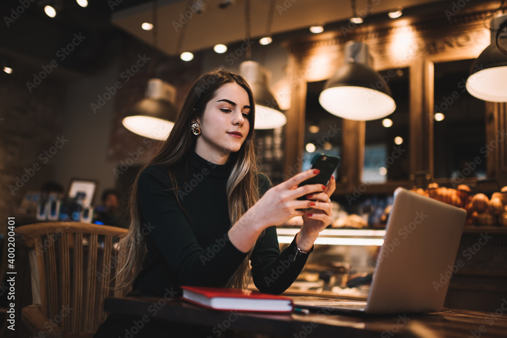 Thoughtful female using smartphone in cafe Thoughtful female using smartphone in cafe