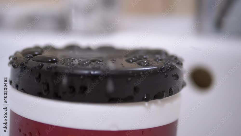 Drops of Water Slowly Fall from Tap and Spray on Black Surface of Plastic Cover Drops of Water Slowly Fall from Tap and Spray on Black Surface of Plastic Cover