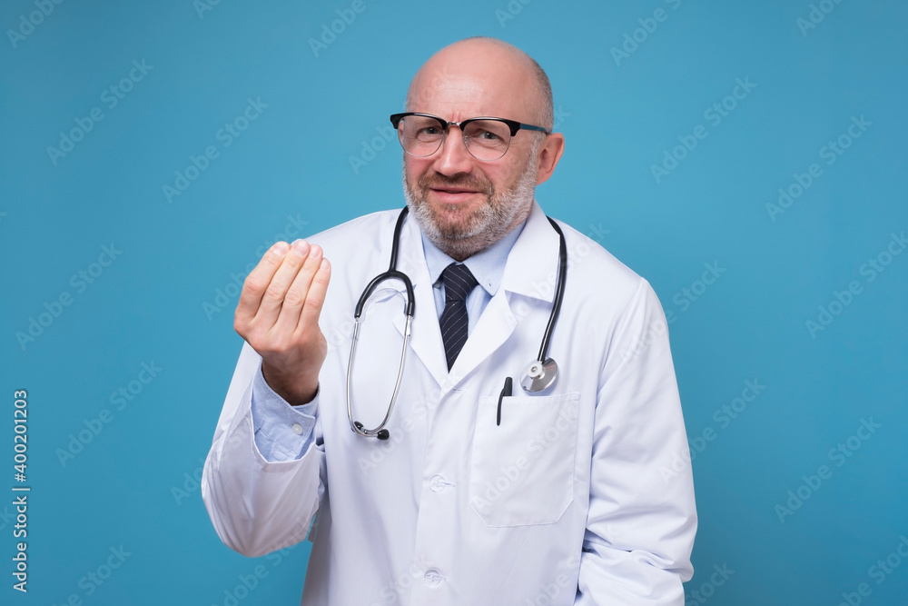 Caucasian male doctor making italian gesture arguing. Studio shot on blue wall. Caucasian male doctor making italian gesture arguing. Studio shot on blue wall.
