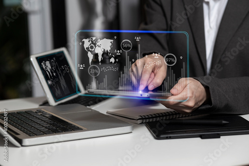 Hands of business woman working on digital tablet computer with documents on office table. Double exposure digital marketing concept.