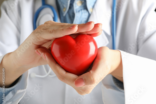 Female doctor with stethoscope holding red heart