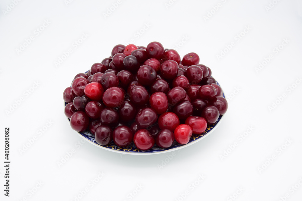 Ripe cherries stacked with a slide on a saucer Ripe cherries stacked with a slide on a saucer
