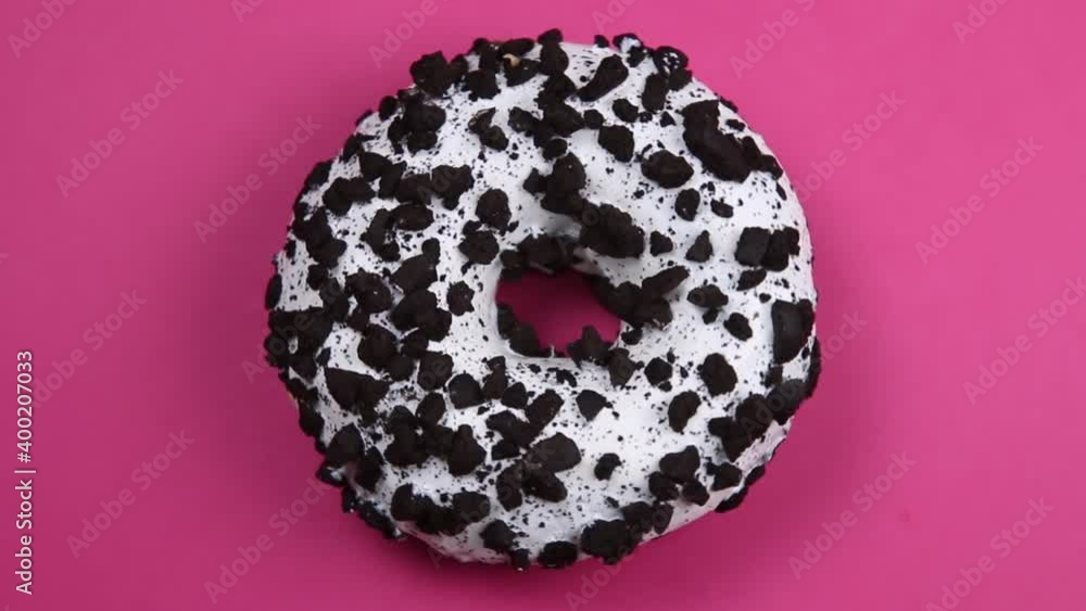 donut with white icing on an pink background. The video rotation donut with white icing on an pink background. The video rotation