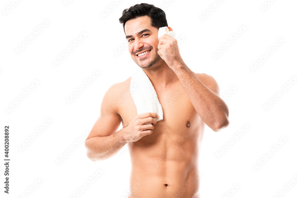 Smiling man cleaning face with towel Smiling man cleaning face with towel