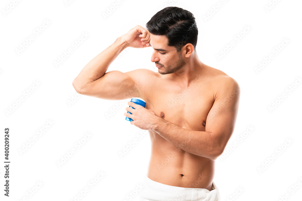 Man takes care of his hygiene by applying deodorant to his armpit Man takes care of his hygiene by applying deodorant to his armpit