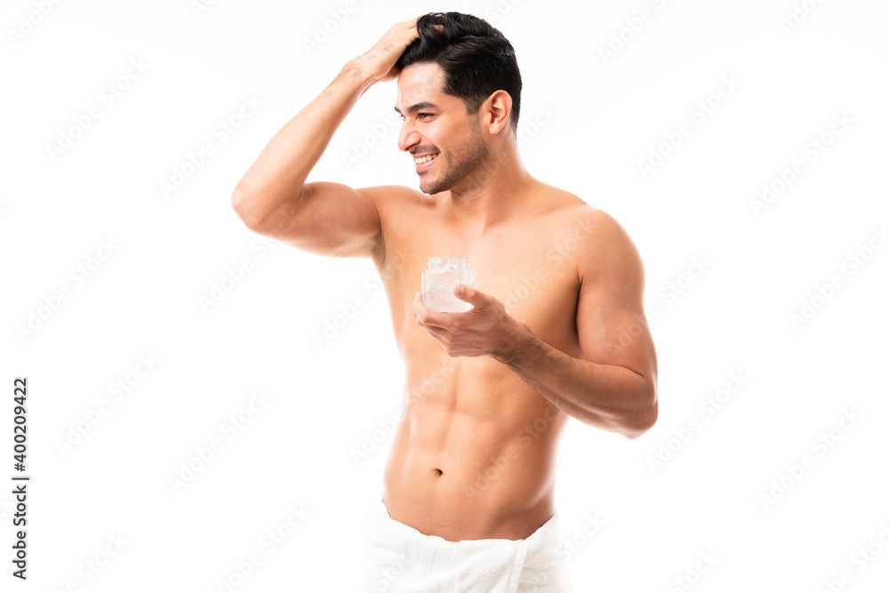 Attractive male applying styling gel on hair Attractive male applying styling gel on hair