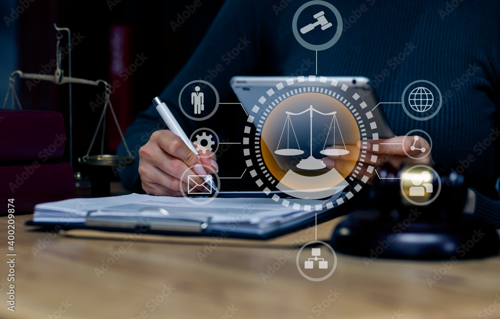 Fototapeta premium Concepts of Law and Legal services. Lawyer woman working with digital tablet and law interface icons at table office.