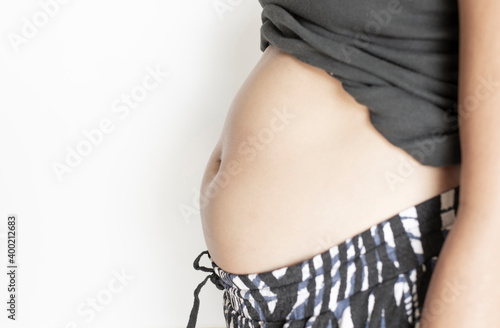 Big belly of a fat woman female with white background with free space photo