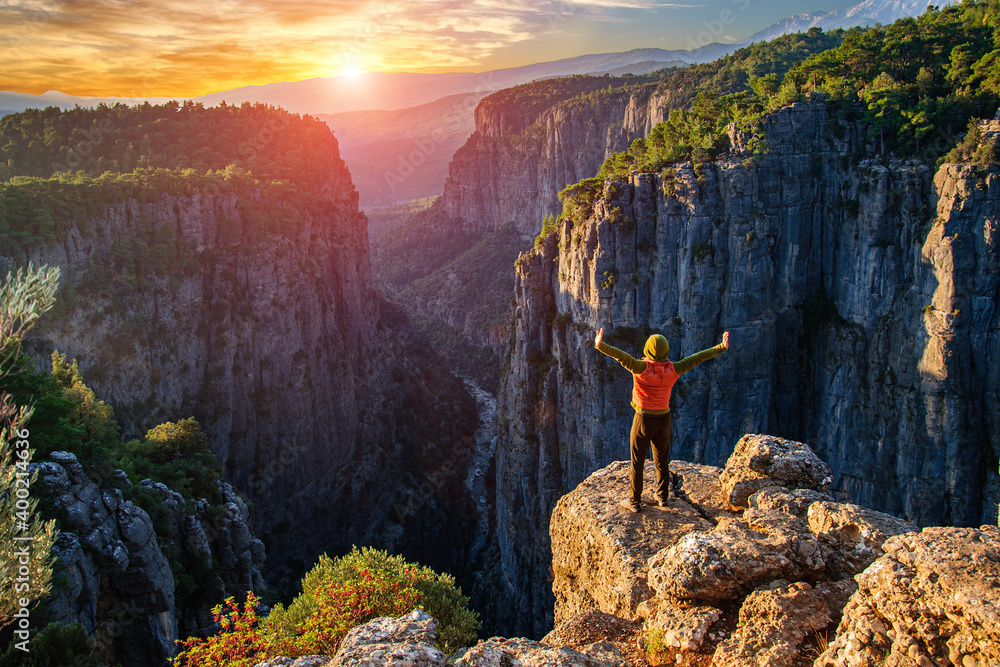 Obraz premium A man meets the sun on the steep slope of the Tazy canyon. Turkey