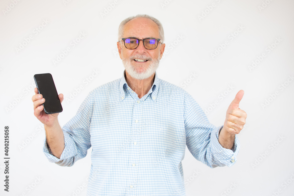 Senior man showing smartphone screen over isolated background happy with big smile doing okay sign, thumb up with fingers, excellent sign Senior man showing smartphone screen over isolated background happy with big smile doing okay sign, thumb up with fingers, excellent sign