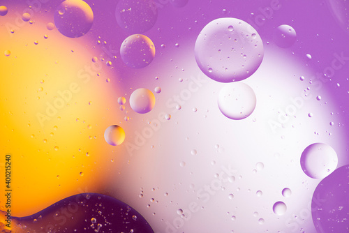 Abstract colorful background of the oil on water surface in yellow, white and lilac shades.