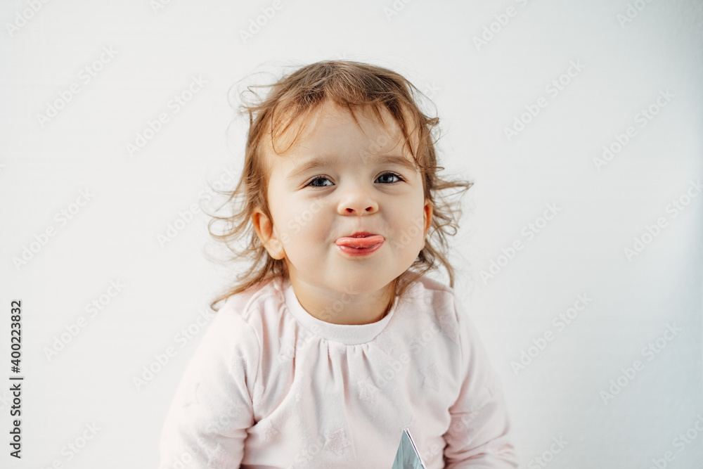 a child on a white background shows his tongue in his mouth, emotions. a child on a white background shows his tongue in his mouth, emotions.