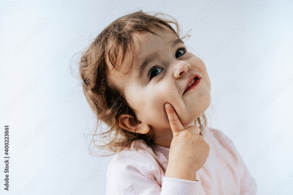 baby girl on white background pen on cheek, dreaming or thinking. emotions. baby girl on white background pen on cheek, dreaming or thinking. emotions.