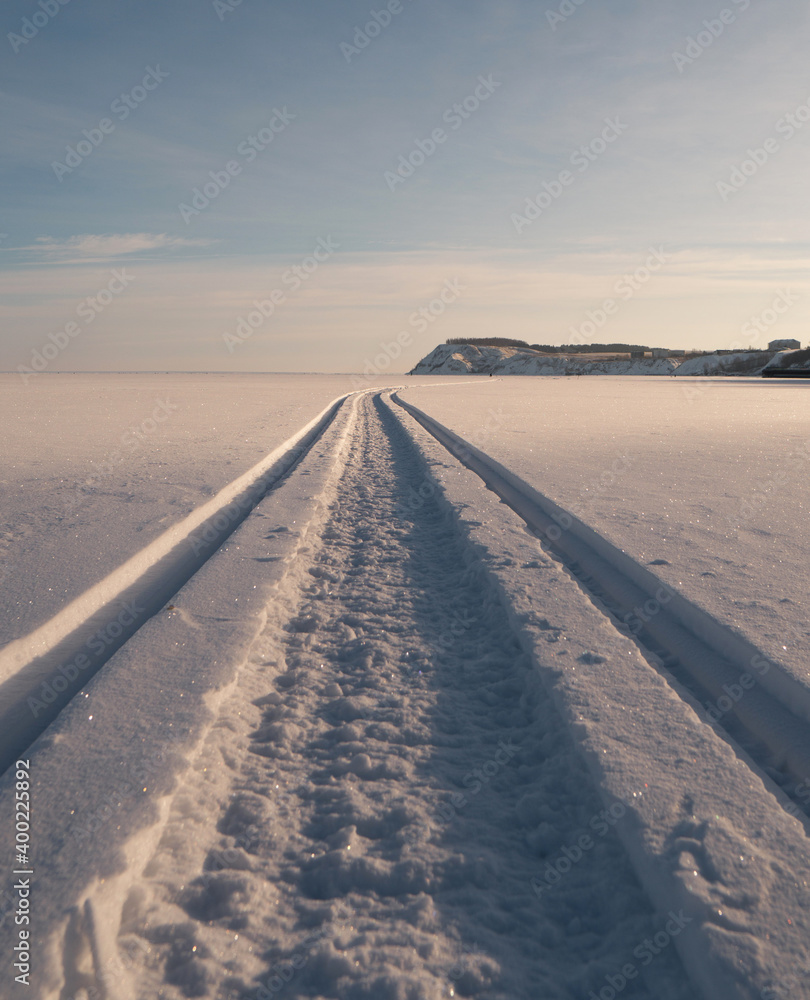 the snowmobile left behind a long strip in the snow the snowmobile left behind a long strip in the snow