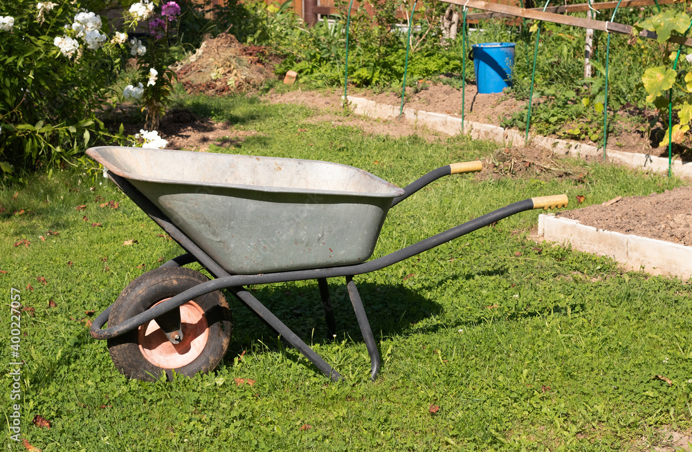empty wheelbarrow in the garden empty wheelbarrow in the garden