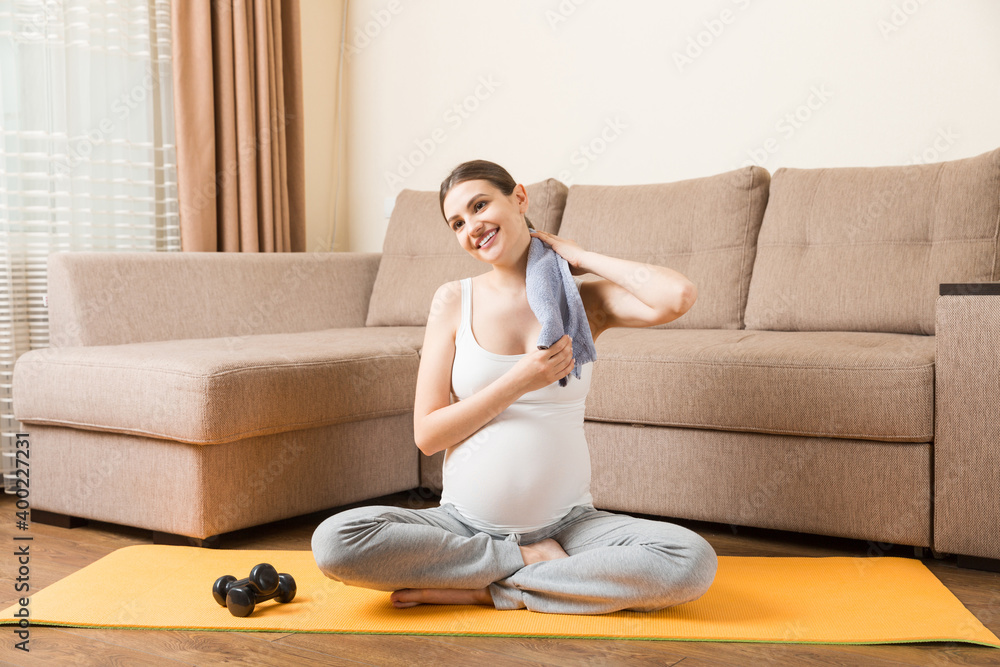 pregnant girl doing yoga with dumbbells at home on a sunny day. coronavirus at home pregnant girl doing yoga with dumbbells at home on a sunny day. coronavirus at home