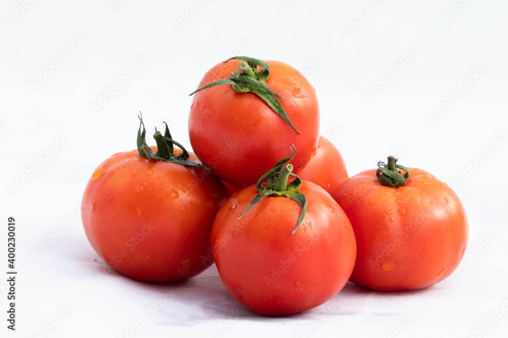 Indian Desi Locally Home Grown Red And Orange Colored Tomatoes Or Tamatar With Green Leaves Stacked Together Isolated On White Background With Blank Copy Space For Custom Text Indian Desi Locally Home Grown Red And Orange Colored Tomatoes Or Tamatar With Green Leaves Stacked Together Isolated On White Background With Blank Copy Space For Custom Text