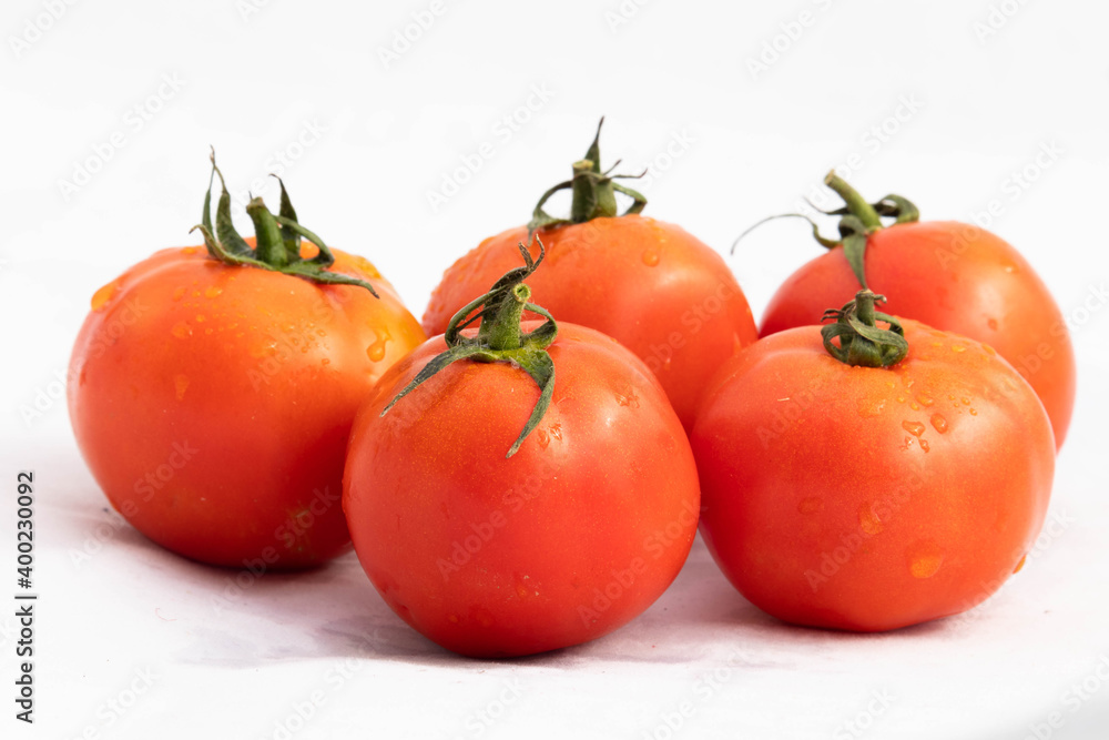 Water Sprinkled On Juicy Red And Orange Vibrant Color Desi Indian Locally Grown Tomatoes Or Tamatar With Green Leaves Decorated Isolated On White Background With Blank Copy Space For Custom Text