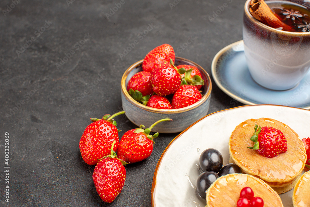 front view little yummy pancakes with fruits and cup of tea on darkgrey background pie cake front view little yummy pancakes with fruits and cup of tea on darkgrey background pie cake