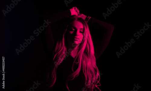 Portrait of fashion young girl in red neon light in the studio. © loran4a
