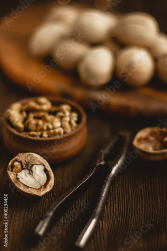 walnuts and nutcracker, whole nuts, walnut shells and kernels on wooden background