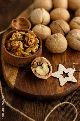 many whole walnuts on a board next to chopped walnuts and walnut kernels on a wooden background