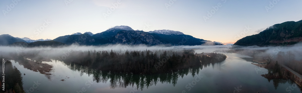 Aerial Panoramic Canadian Nature Landscape with mountains in background. Sunny Sunrise Sky. Taken in Squamish, North of Vancouver, British Columbia, Canada.