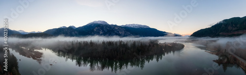 Fototapeta Naklejka Na Ścianę i Meble -  Aerial Panoramic Canadian Nature Landscape with mountains in background. Sunny Sunrise Sky. Taken in Squamish, North of Vancouver, British Columbia, Canada.