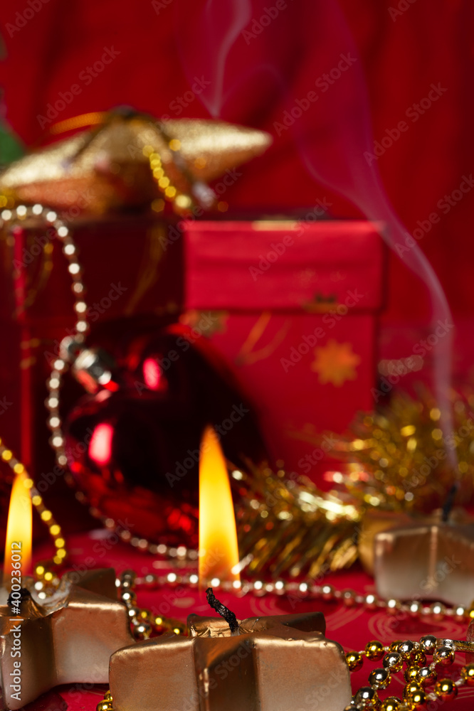 Christmas burning candles with decorations and  presents  at red background. Christmas holiday concept