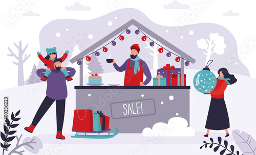 Family walking and having fun at christmas market. Merchant sells hot drinks at winter fair. People buy gifts for loved ones at holiday fair