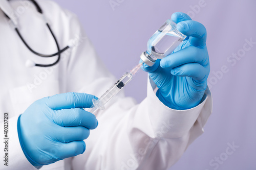 Doctor with a stethoscope on shoulder holding syringe and new vaccine. Healthcare And Medical concept. Development and creation of a coronavirus vaccine COVID-19 . Coronavirus Vaccine.