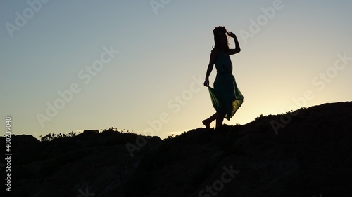 silhouette of a girl standing with a dress
