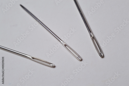 three sewing needles on a white background. close-up.