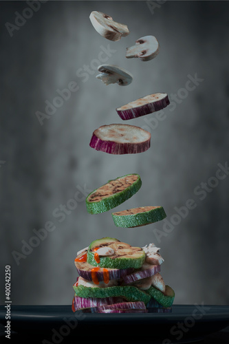 A towel of Courgette , egg plant and mushroom falling down on a plate