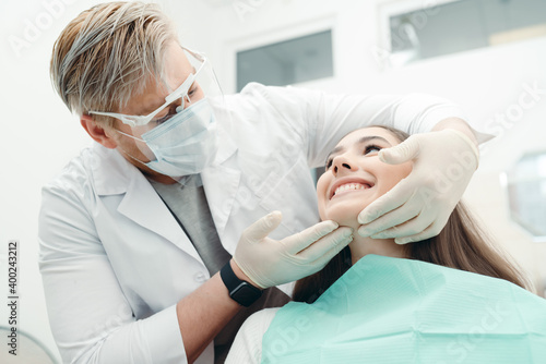 Dentist checks the quality of the teeth of a patient sitting in a dental chair