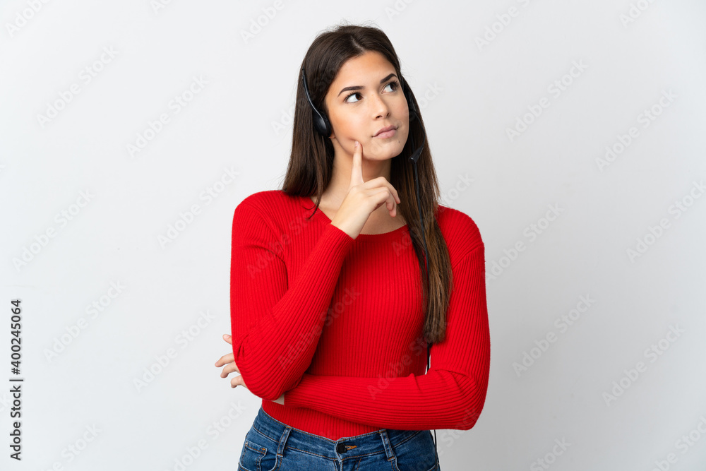 Young Brazilian telemarketer girl over isolated background having doubts while looking up Young Brazilian telemarketer girl over isolated background having doubts while looking up