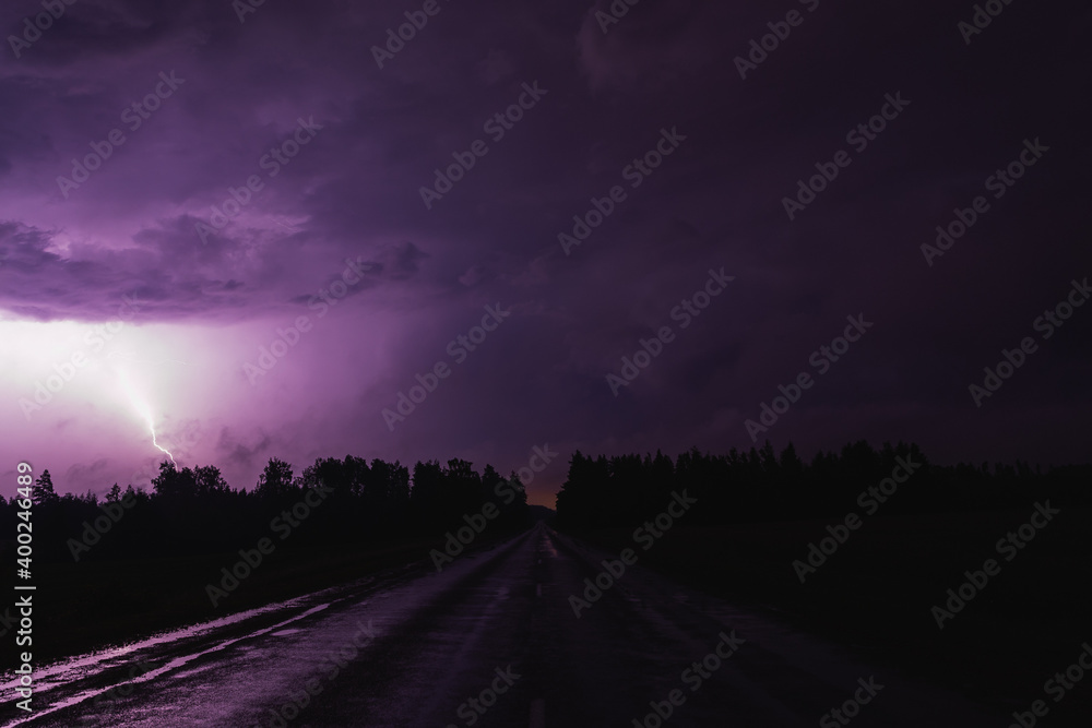 clouds over the city at night lightning dark asphalt road purple violet  lit up thunder